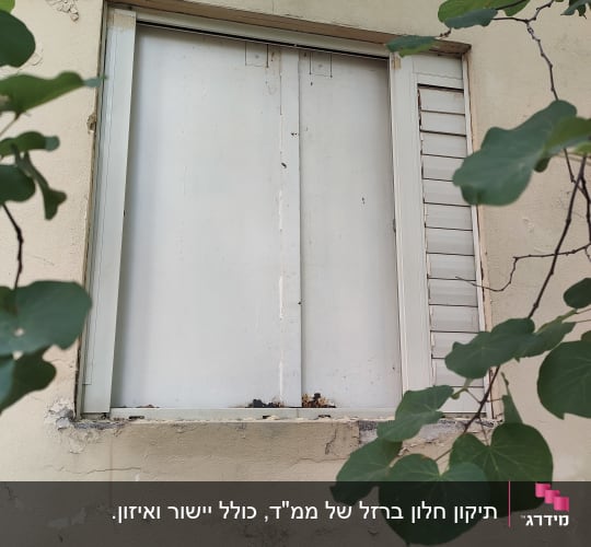 חלון עם תריסים לבנים במסגרת קיר חיצוני